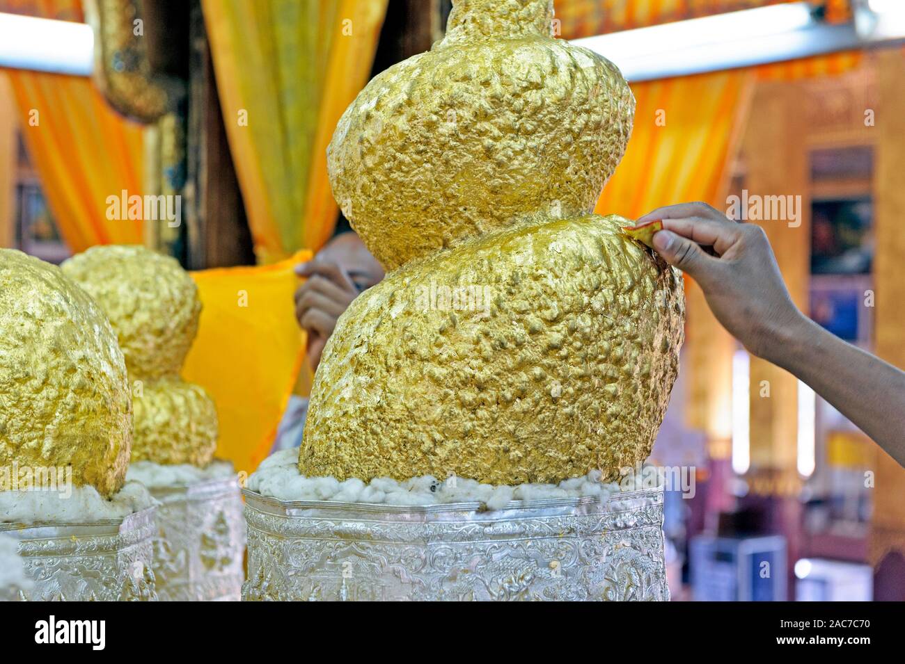 Mann, der eine Blattgold-Wafer auf die Buddha-Statue in der Phaung Daw Oo-Pagode legt. Inle Lake Myanmar Burma Stockfoto