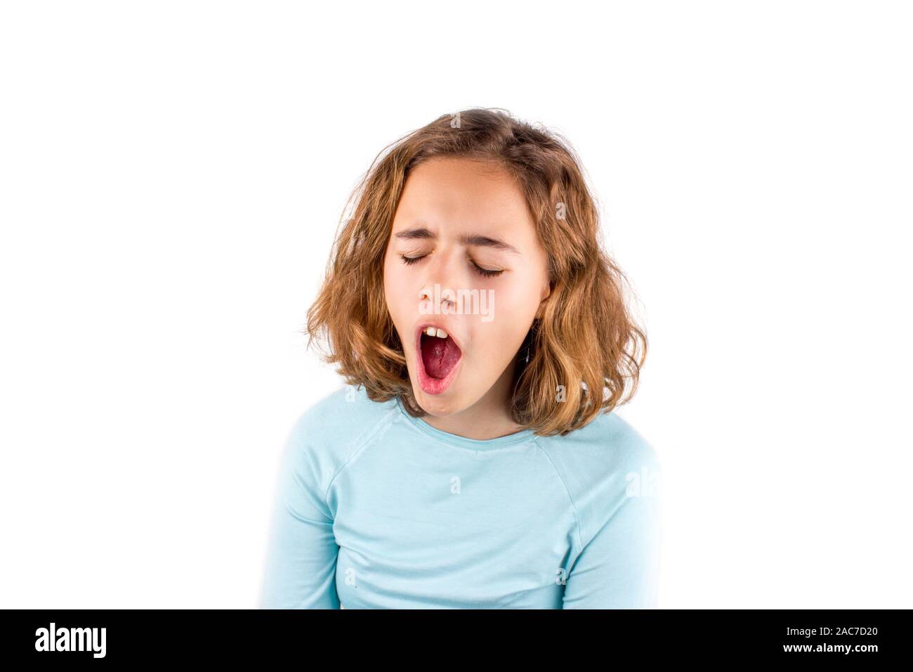 Schöne junge Mädchen mit lockigem Haar singt mit offenen Mund. Gähnen Mädchen Stockfoto