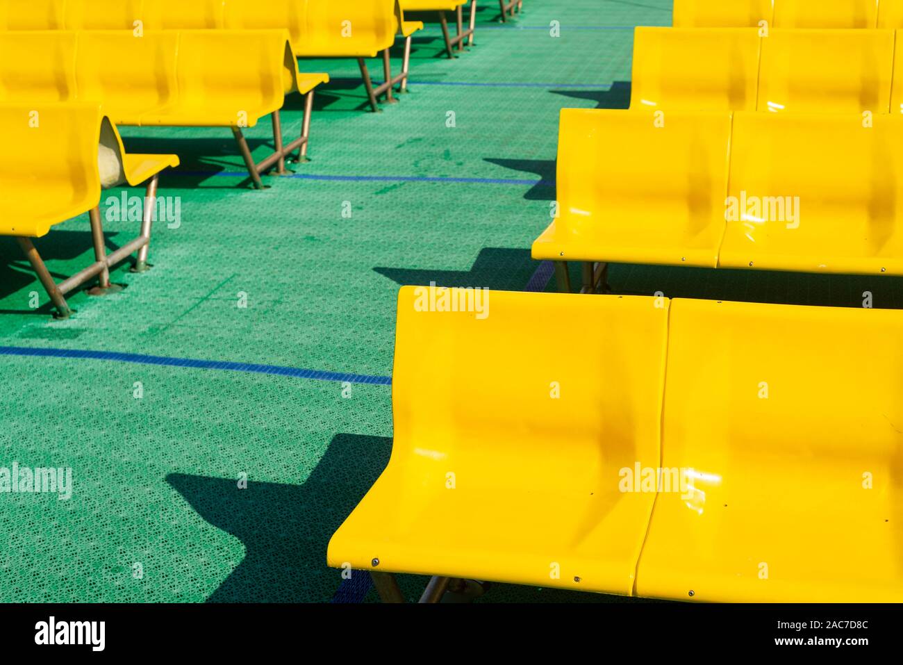 Reihen von leeren Gelb sitzen vor Grün Kunststoff auf dem Oberdeck eines Jadrolinija Fähren in Kroatien Stockfoto