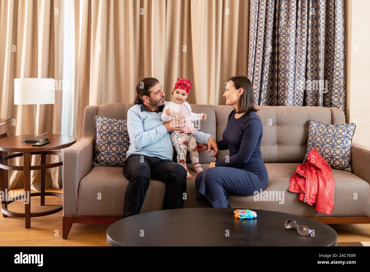 Glückliche Familie sitzt und mit Ihrem Kind zu Hause spielen. Stockfoto