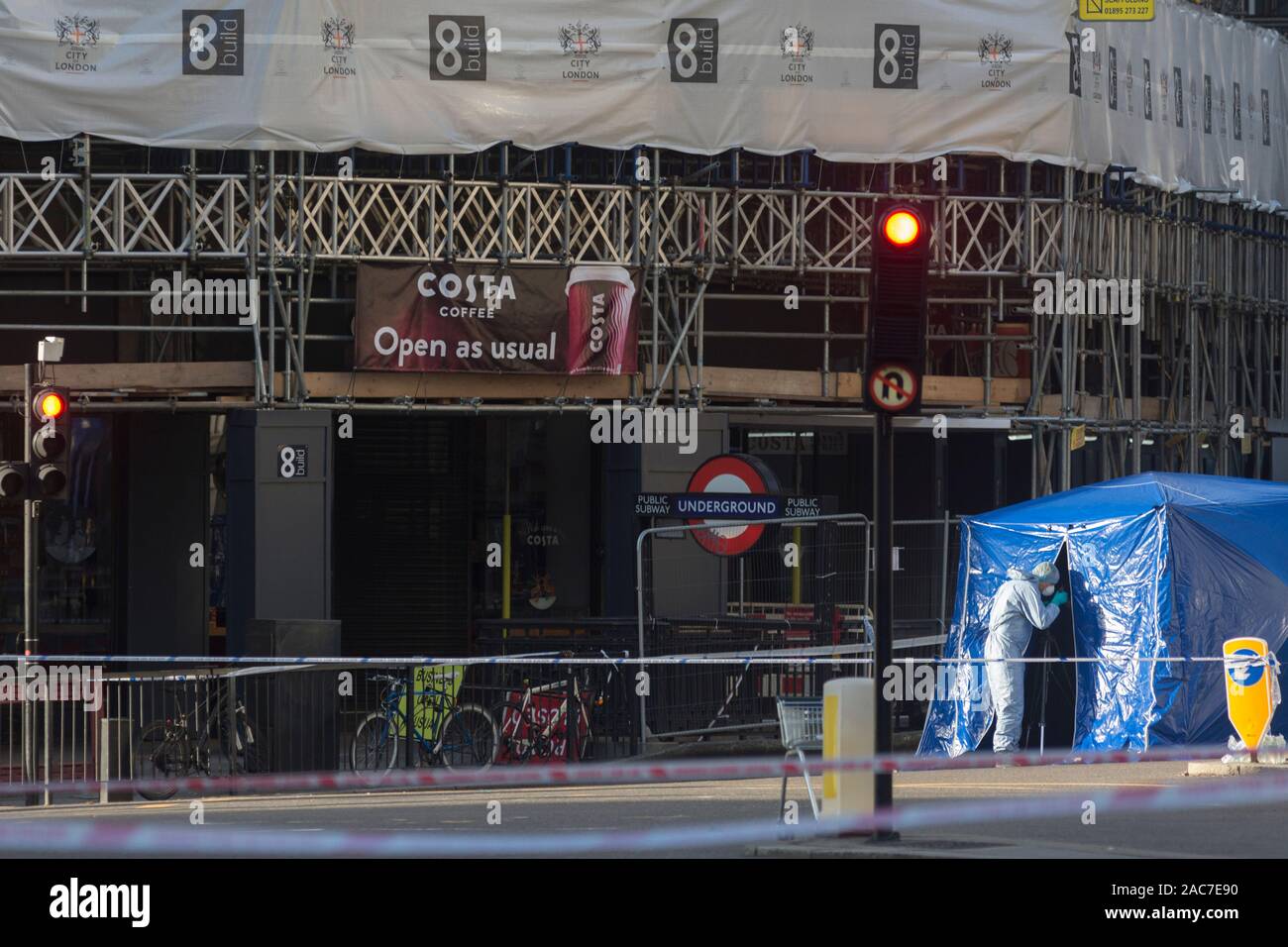 Der Morgen nach dem Terroranschlag in Fischhändler Halle auf der London Bridge, in denen Usman Khan (ein Verurteilter, terroristische befreit) 2 tötete bei einem Messer ein Angriff, anschließend von den Passanten in Angriff genommen - Durch und durch bewaffnete Polizei erschossen - Forensische Offiziere Arbeiten zur Aufnahme von Beweismaterial vor einem Eingang zur U-Bahnstation Monument, am 30. November 2019 in London, England. Stockfoto