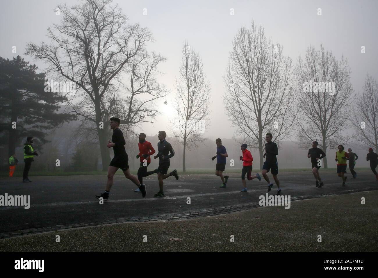 Athleten jog inmitten dichter Nebel in Finsbury Park, nördlich von London. Stockfoto