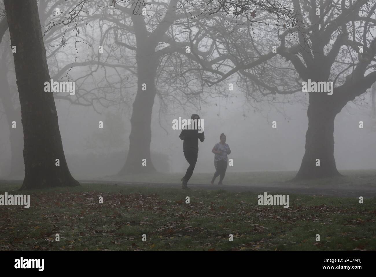 Athleten jog inmitten dichter Nebel in Finsbury Park, nördlich von London. Stockfoto