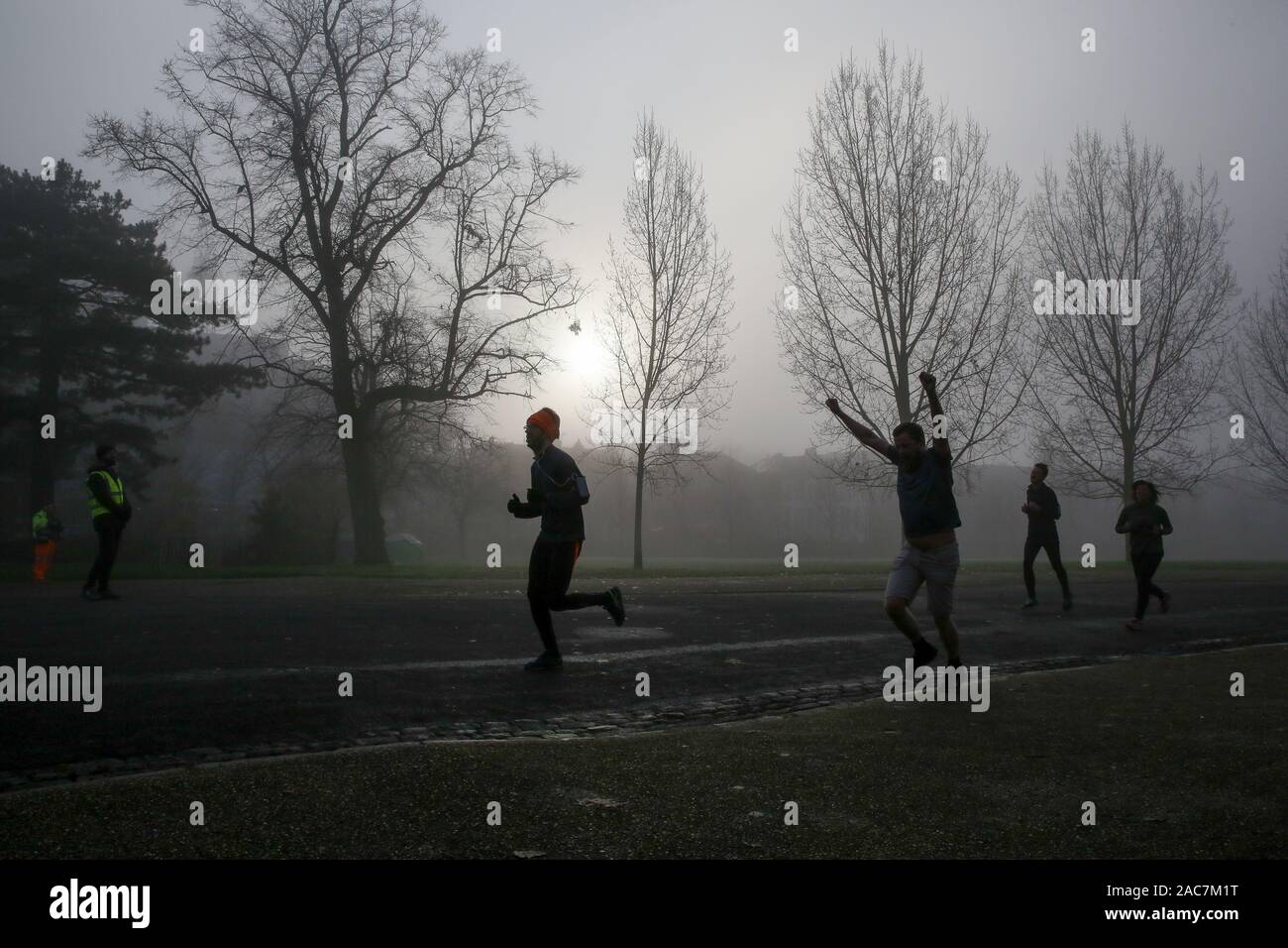Athleten jog inmitten dichter Nebel in Finsbury Park, nördlich von London. Stockfoto