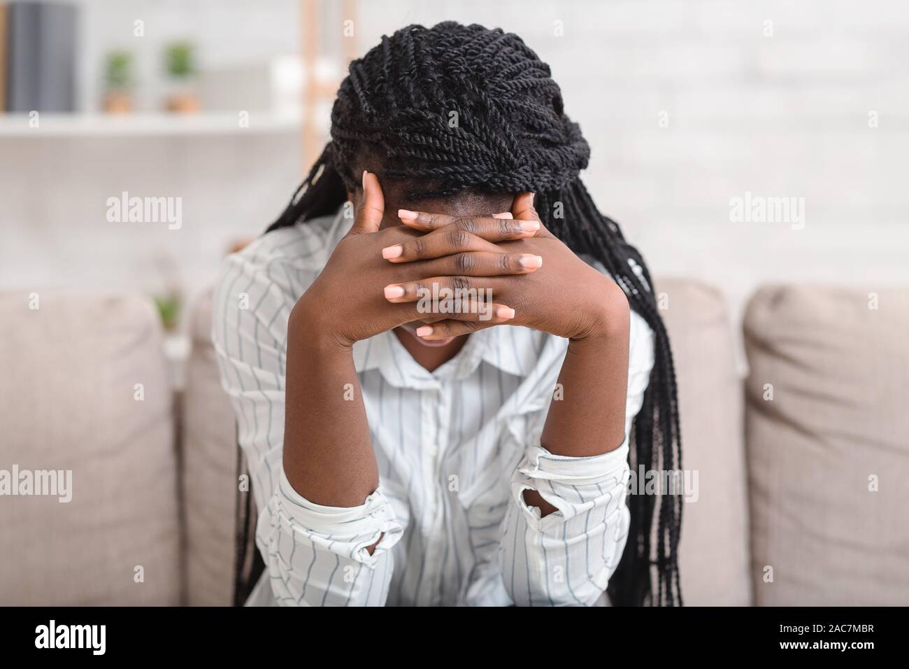 Deprimiert Frau alleine zu Hause zu sitzen, den Kopf berühren in der Verzweiflung Stockfoto