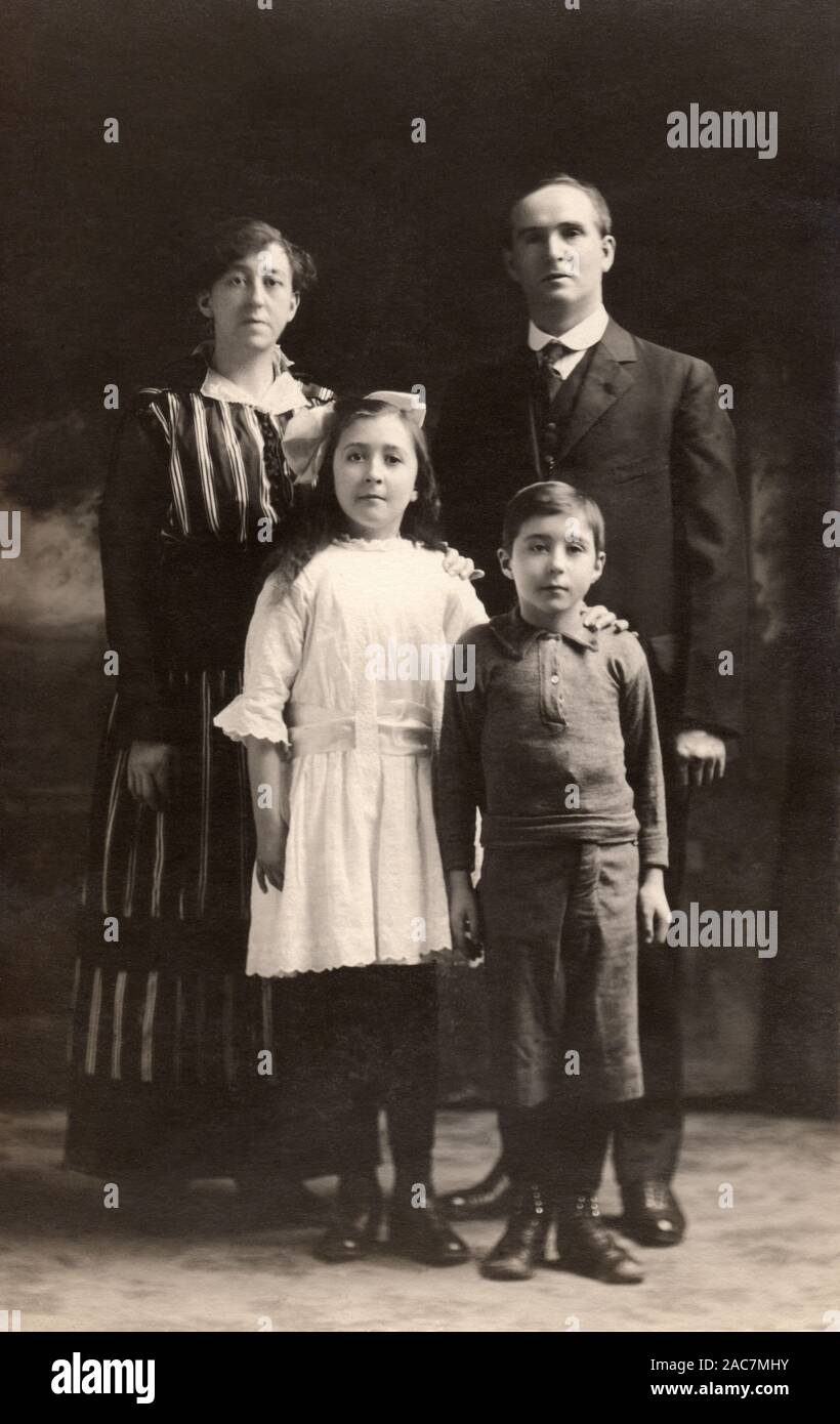Jahrgang fotografische Postkarte Bild einer vierköpfigen Familie um 1910. Stockfoto