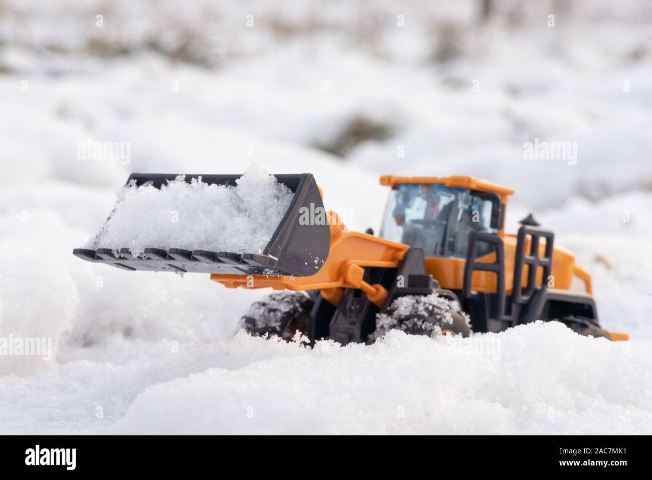 Ein Spielzeug Traktor Reinigung Straße von einem Schnee Konzept. Stockfoto