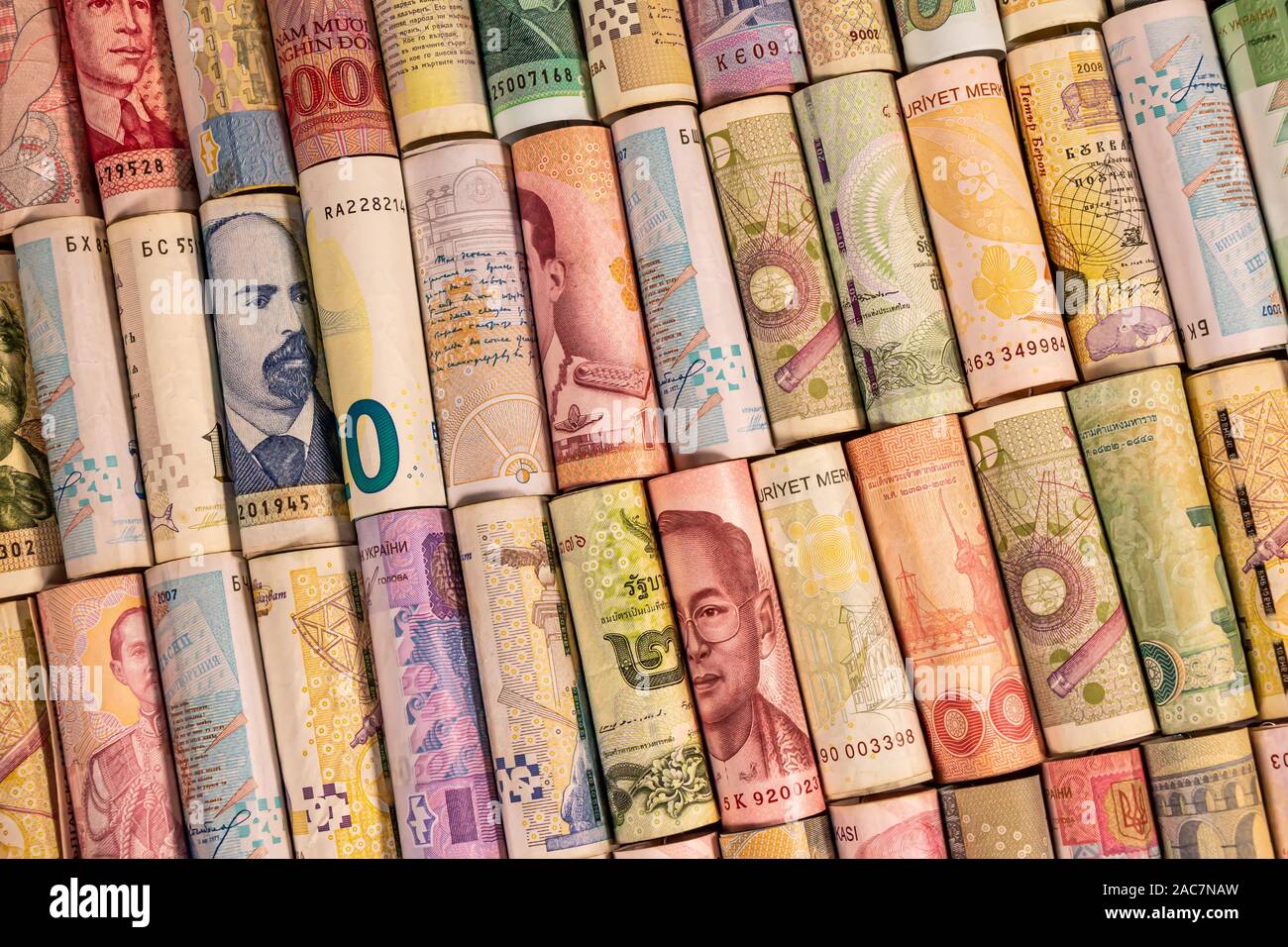 Verschiedene bunte Banknoten aus verschiedenen Ländern auf Rollen für die Illustration von Themen wie Handel, Banken, Medien, etc. Stockfoto