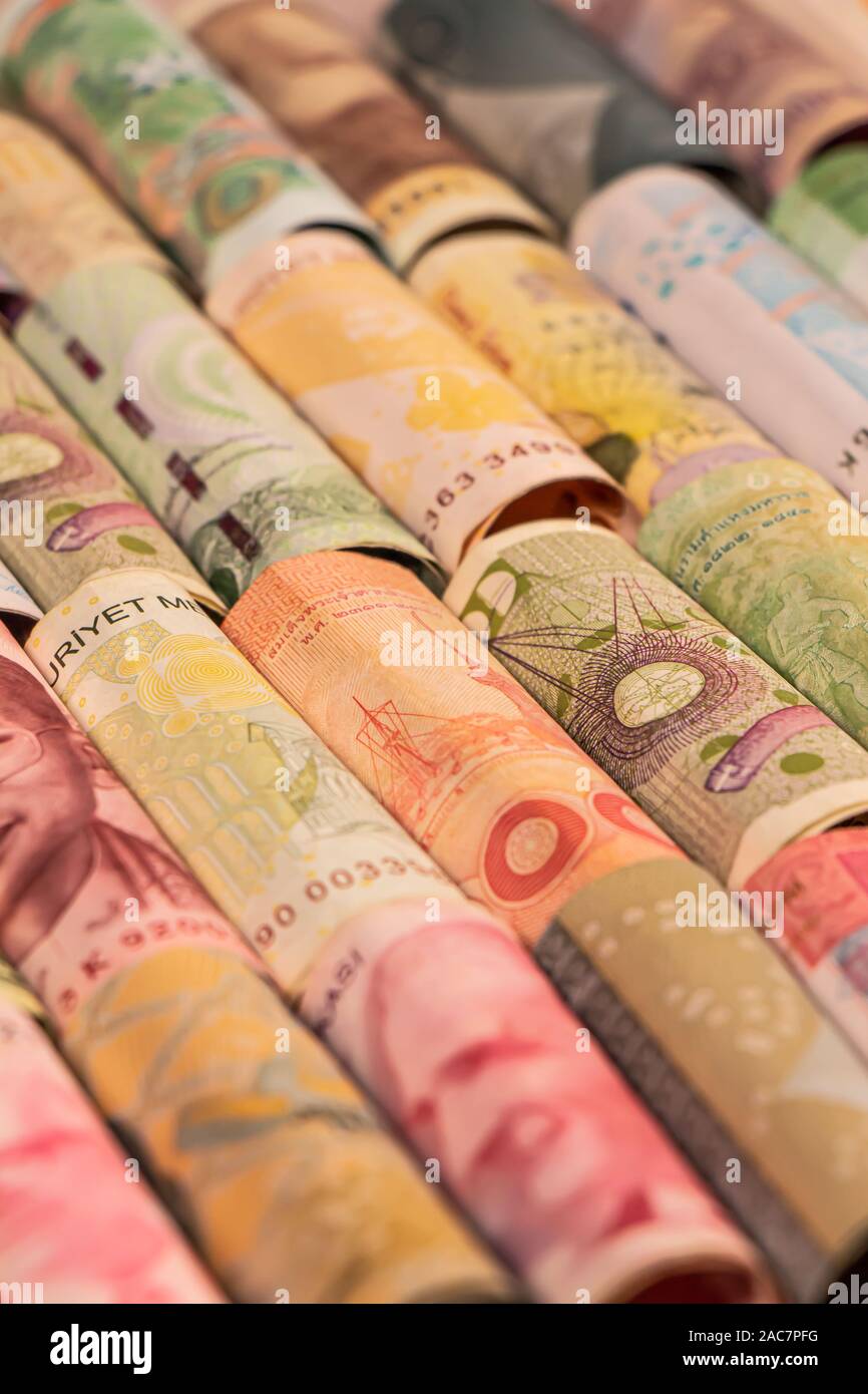 Verschiedene bunte Banknoten aus verschiedenen Ländern auf Rollen für die Illustration von Themen wie Handel, Banken, Medien, etc. Stockfoto