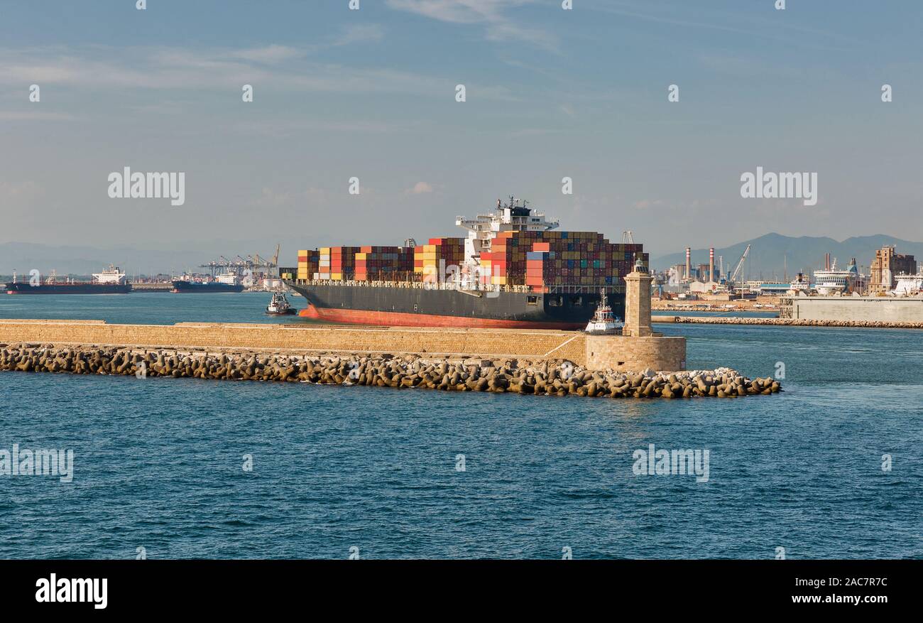 Schlepper und riesige Container Containerschiff Eingabe der Hafen von Livorno, Toskana, Italien. Stockfoto