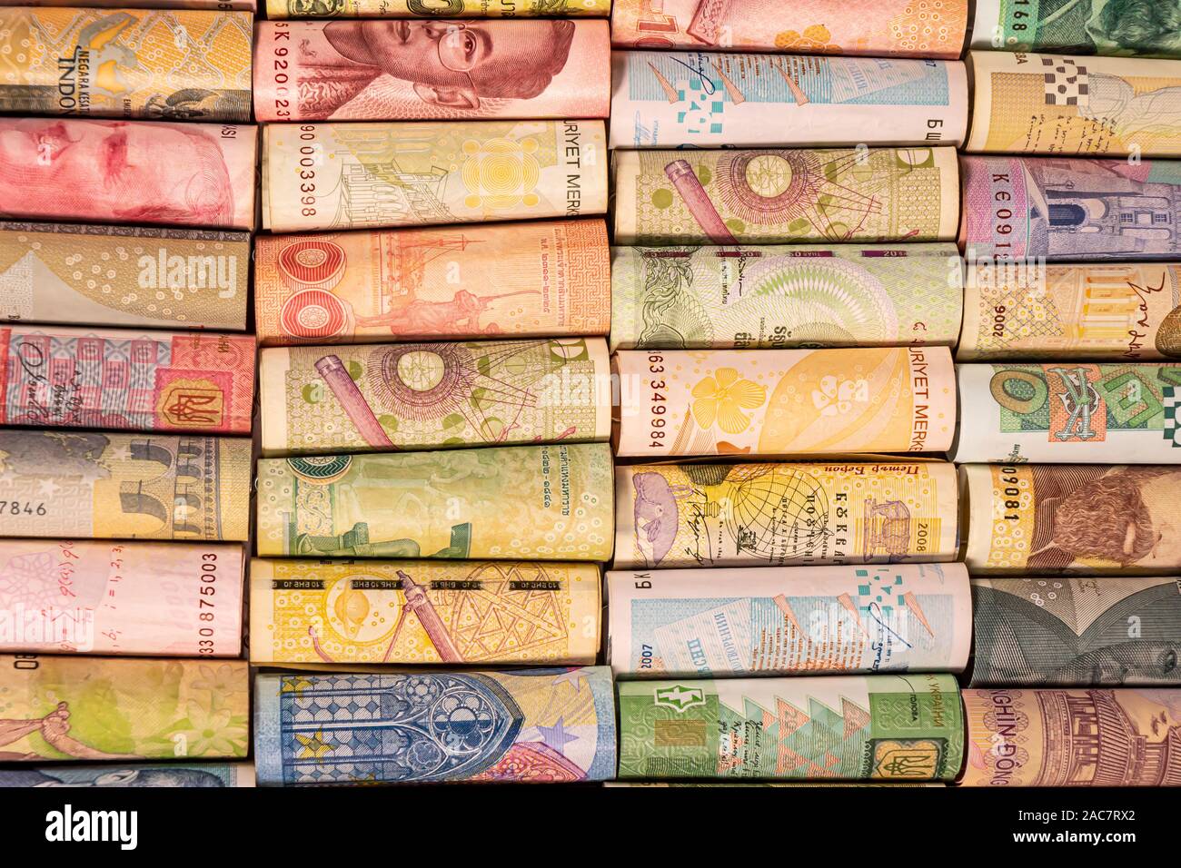 Verschiedene bunte Banknoten aus verschiedenen Ländern auf Rollen für die Illustration von Themen wie Handel, Banken, Medien, etc. Stockfoto