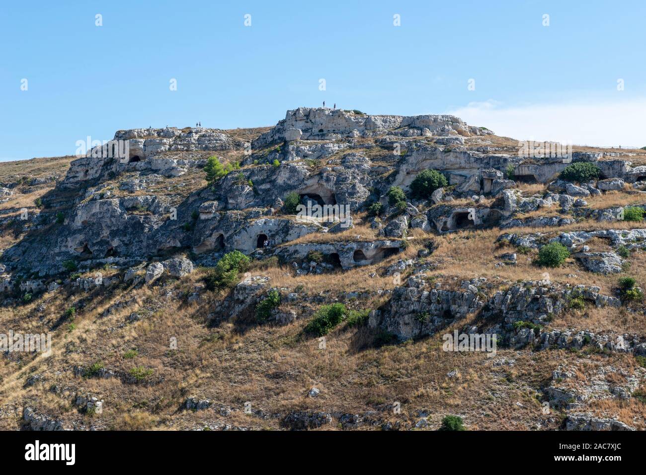 Frühe rock Höhlenwohnungen auf den Klippen von La Gravina di Matera, eine tiefe Schlucht um den Rand von Matera, Basilikata, Süditalien läuft Stockfoto