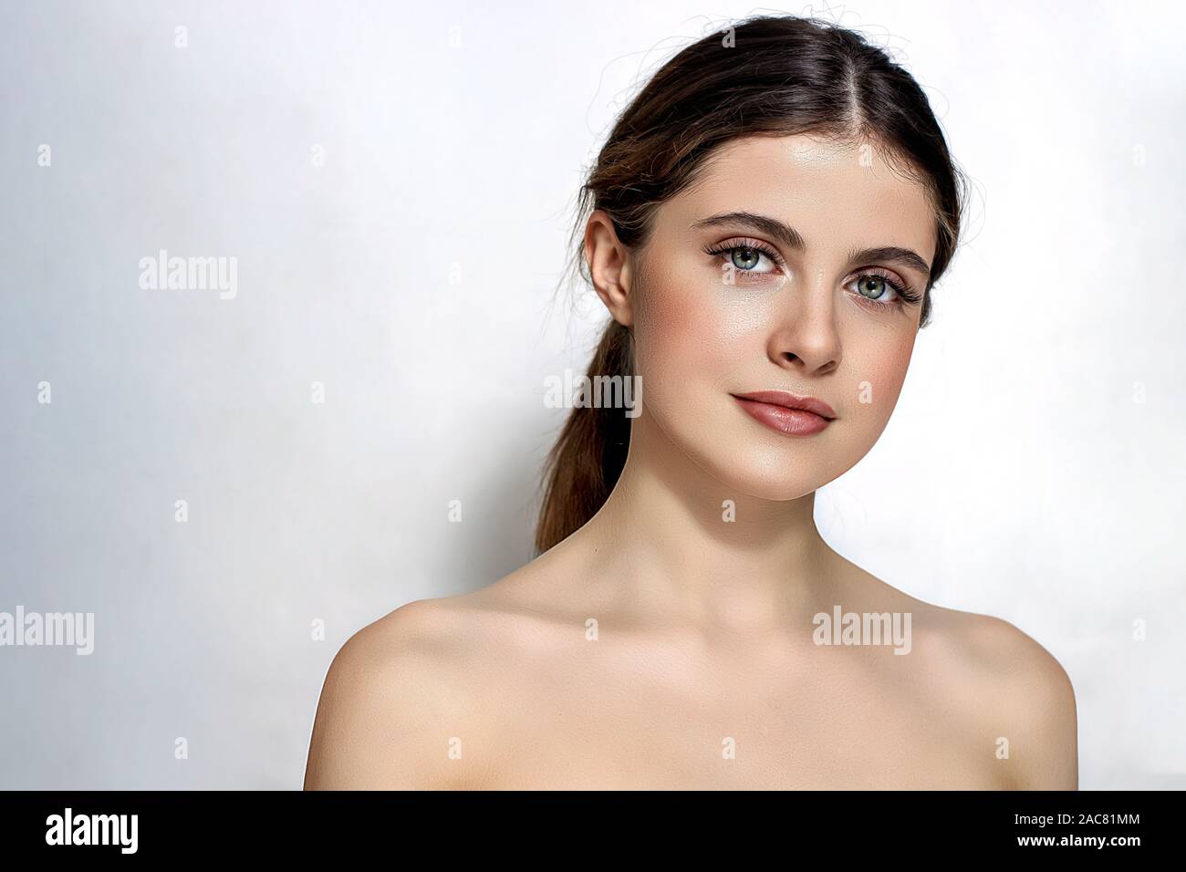 Schöne junge Frau mit sauberem perfekte Haut. Porträt einer schönen braunen Haaren Modell mit natürlichen nude Make-up auf einem weißen Hintergrund. Wellness, Haut ca Stockfoto