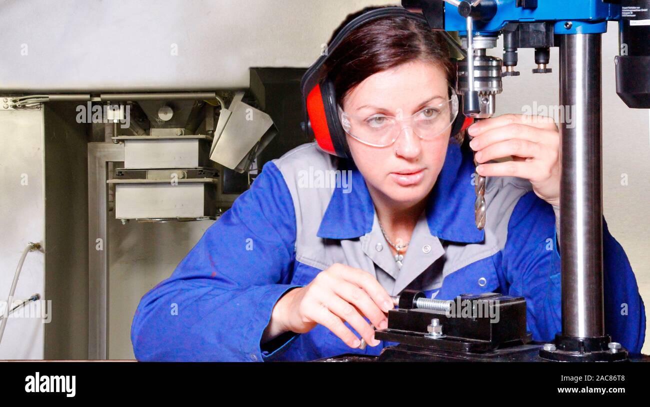 Professionelle Frau arbeiten mit einer elektrischen Bohrmaschine Stockfoto
