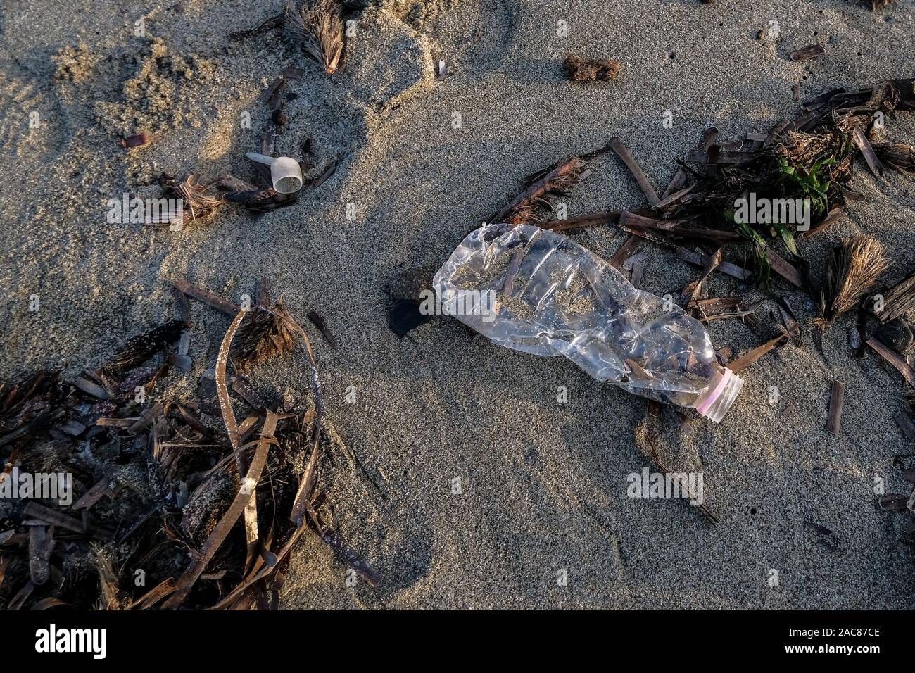 Plastikflasche auf wilde Küste über Verschwommenes Wellen Hintergrund, unseren Planeten zu retten Stockfoto