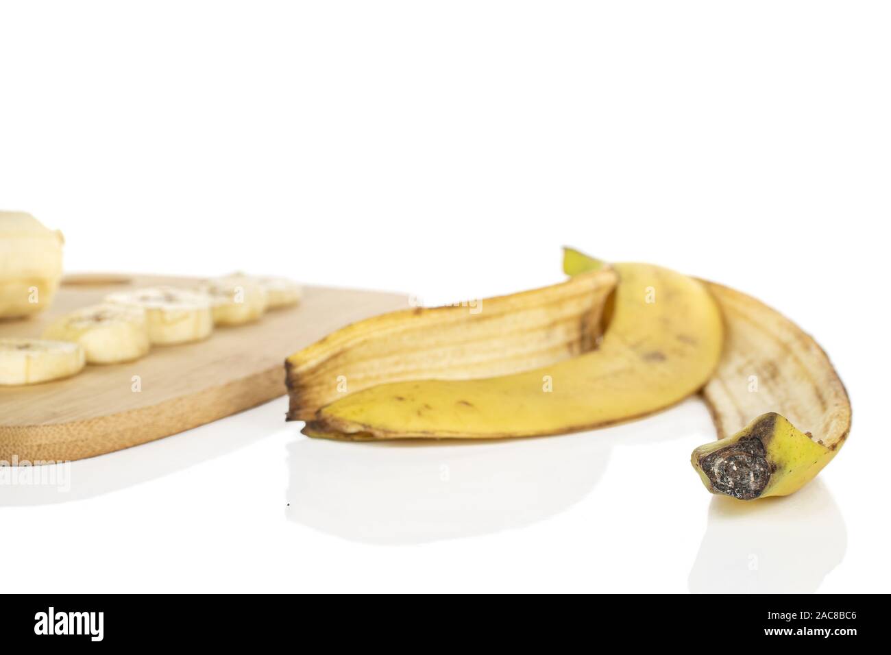 Gruppe von vier Scheiben zwei süße gelbe Banane auf Bambus Schneidbrett auf weißem Hintergrund Stockfoto