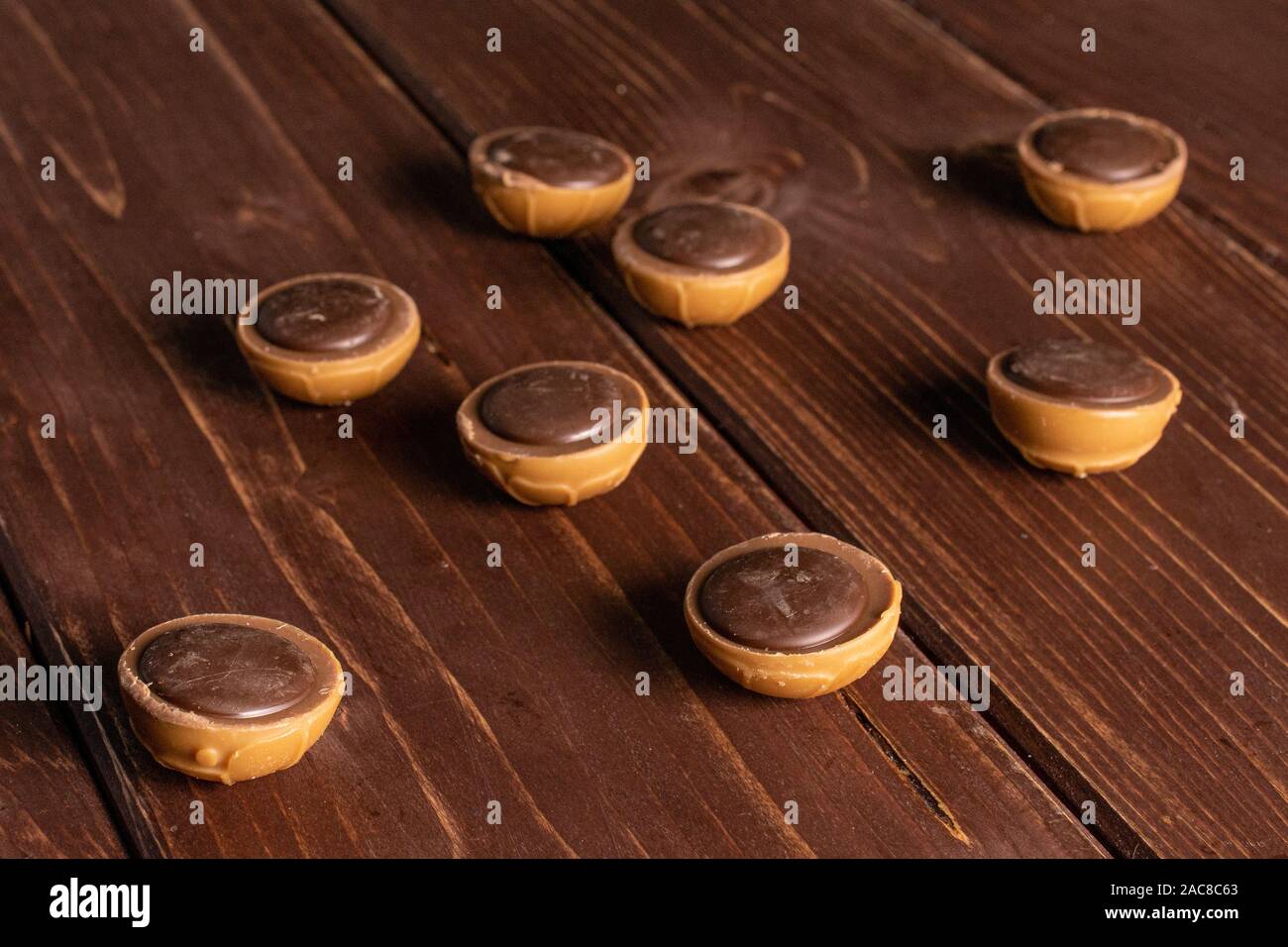 Gruppe der Acht ganze süsse braune Toffee auf braunem Holz Stockfoto