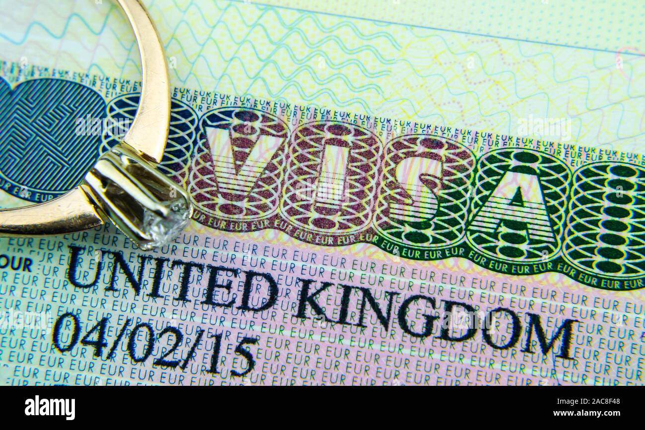 UK Visa Aufkleber in den Reisepass und das Engagement Diamond Ring oben platziert. Konzept Foto für für Partner und Ehepartner Visum GROSSBRITANNIEN. Makro Foto. Stockfoto