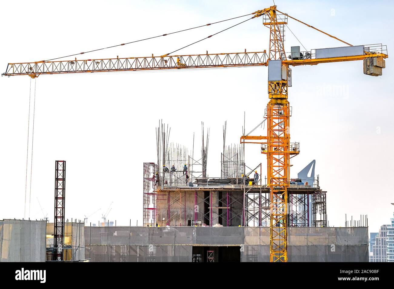 Luftaufnahme der Gebäudekonstruktion mit Turm Kran, Gerüst, Schalung, Ausrüstung und Arbeit Mannschaften platzieren Betonstahl Bars. Stockfoto