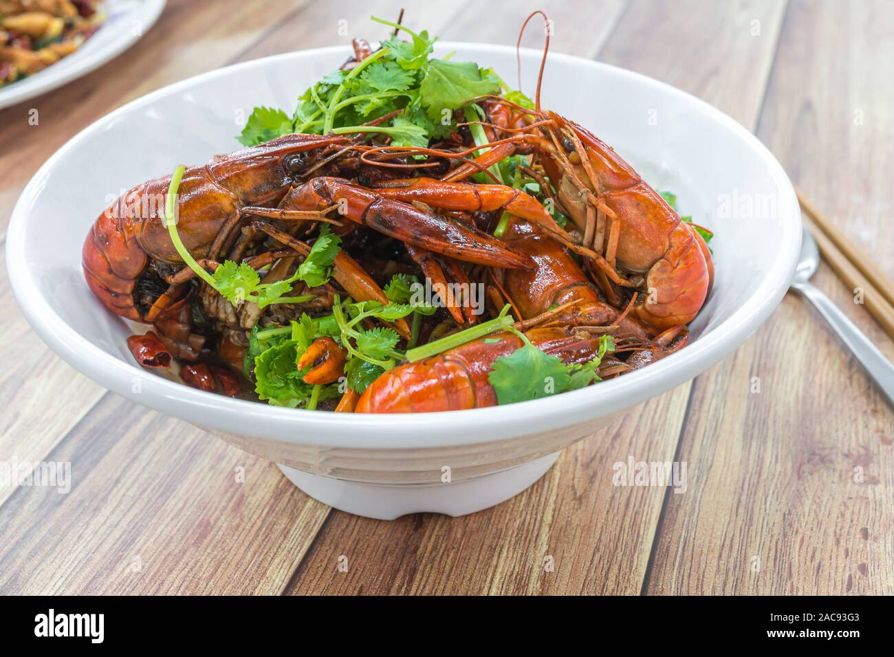 Chongqing Sichuan würzigen getrockneten Chili Kleine Hummer, neben anderen Gerichten im Hintergrund. Essen Fotografie an chinesischen Restaurant. Stockfoto