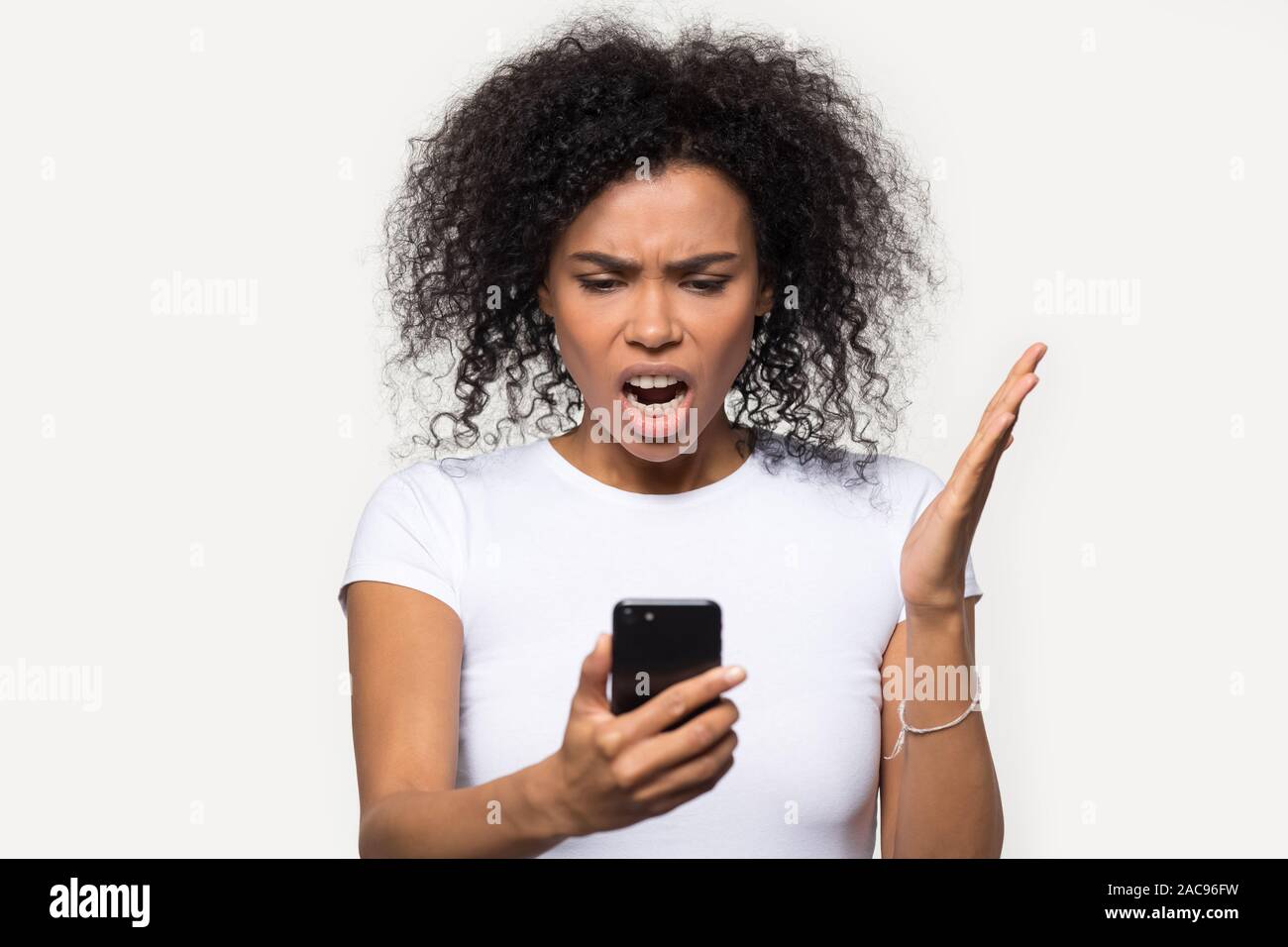 Wütend afrikanische amerikanische Frau am Telefon, genervt von Spam Stockfoto