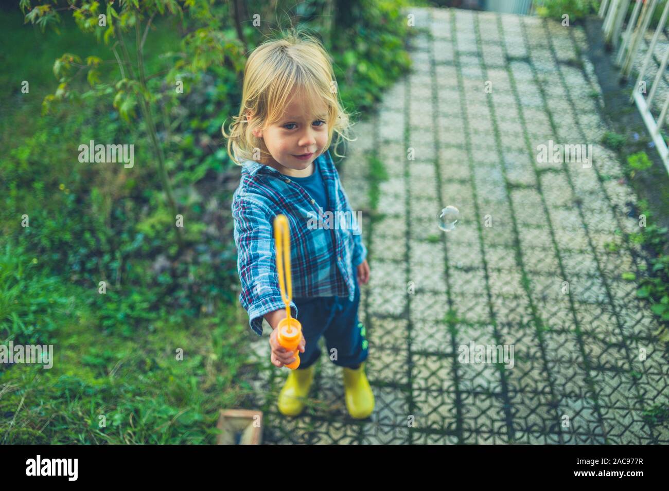 Ein kleines Kind Seifenblasen im Garten Stockfoto