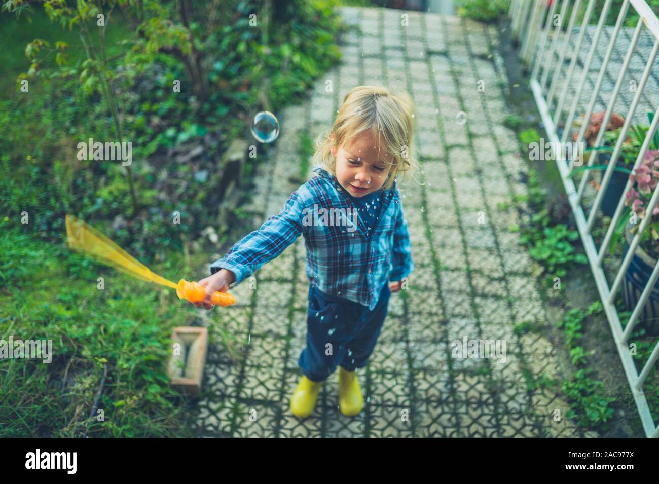 Ein kleines Kind Seifenblasen im Garten Stockfoto