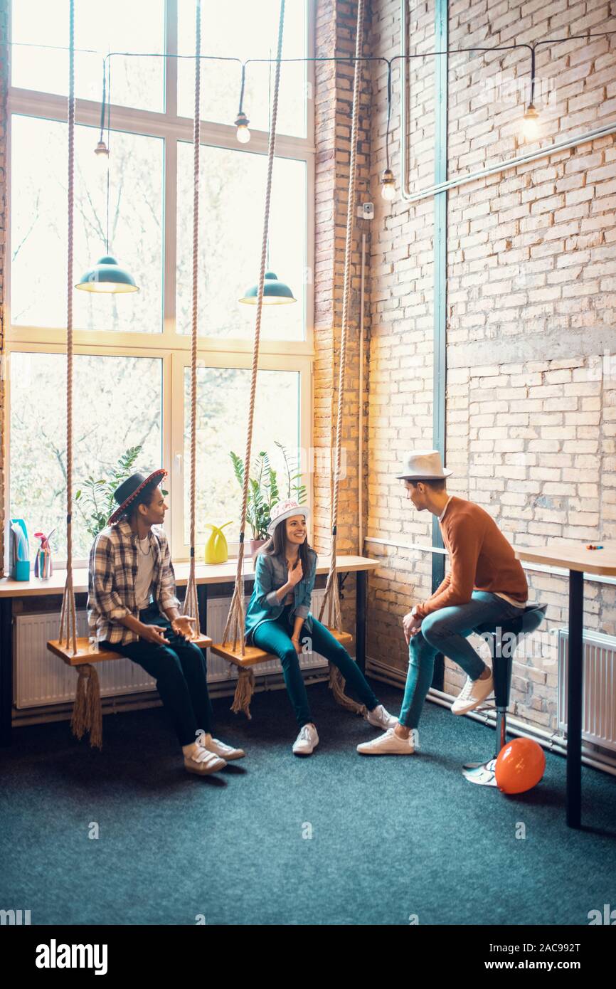 In der Nabe. Stilvolle gut aussehende Freiberufler tragen Hüte mit Small Talk in der Nabe Stockfoto