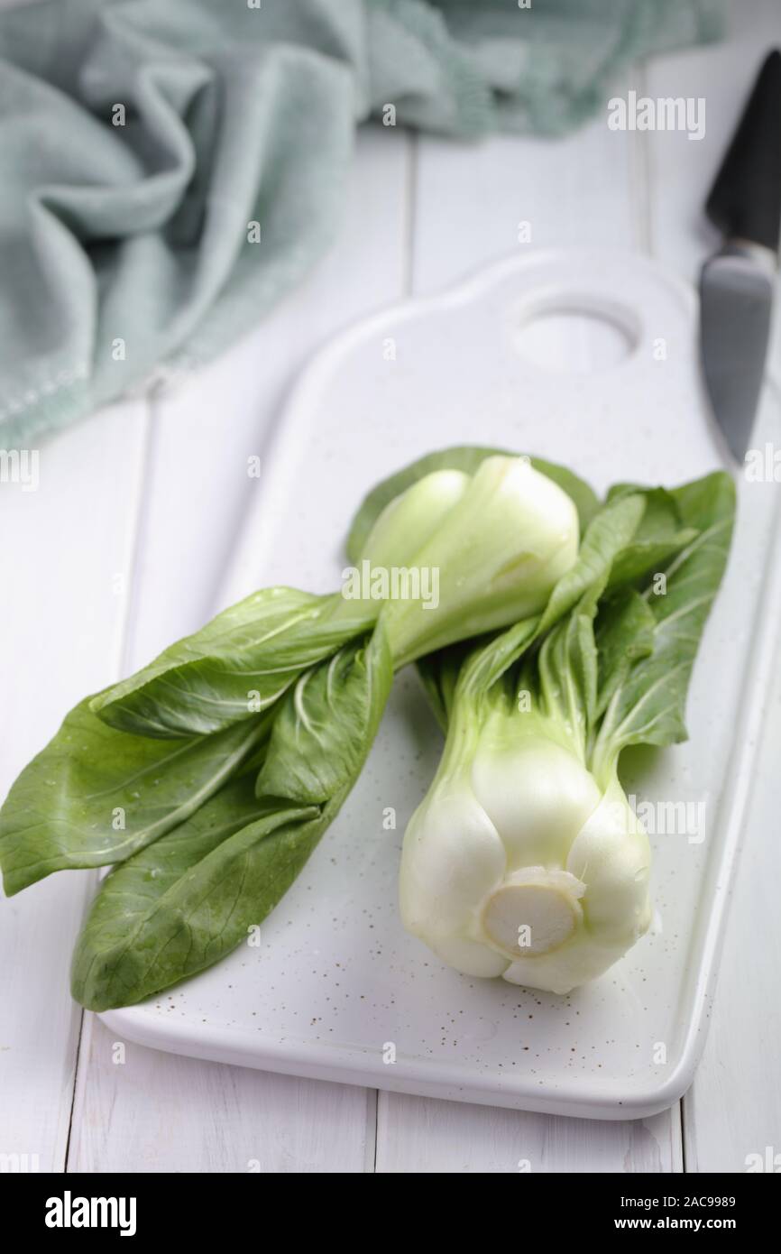 Bok Choy, die Vielfalt der Chinakohl auch bekannt als Pak Choi, Pok Choi, auf einem weißen Schneidebrett Stockfoto