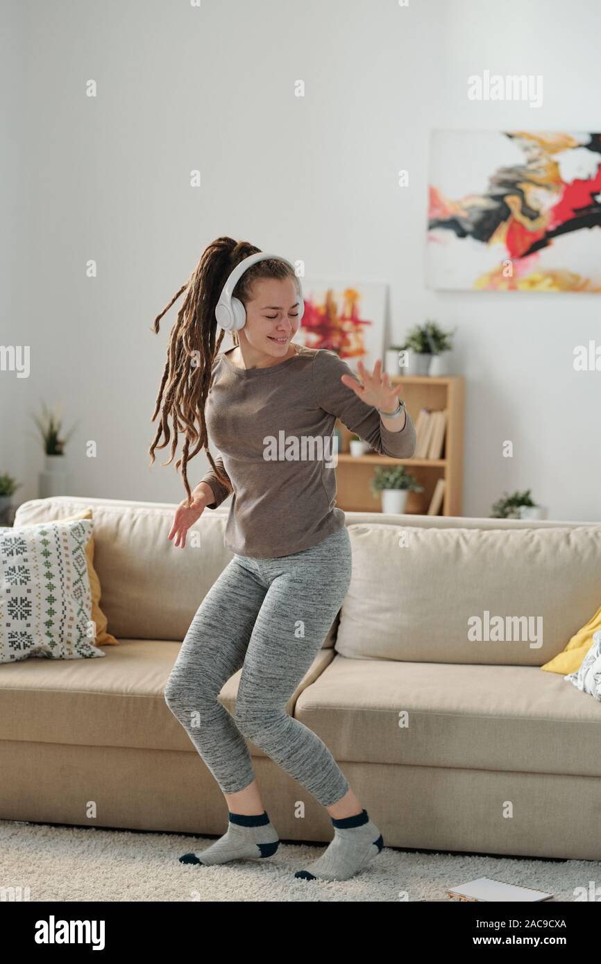 Junge fröhliche energische Frau, activewear Tanzen durch die Musik im Kopfhörer Stockfoto