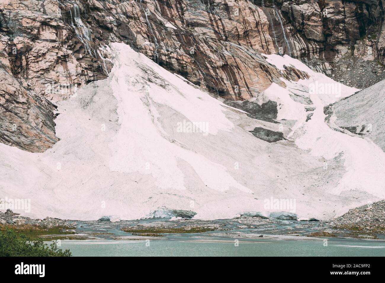 Jostedalsbreen Nationalpark, Norwegen. Nahaufnahme vom Schmelzen von Eis und Schnee, kleinen Wasserfällen auf Boyabreen Gletscher im Sommer sonnigen Tag. Berühmte Norwegi Stockfoto