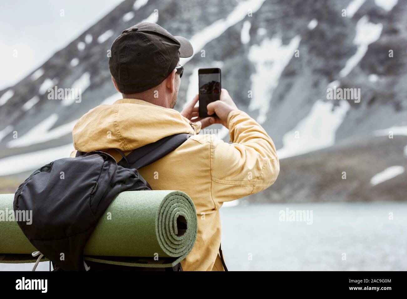 Männliche Wanderer nimmt mobile Photo von Bergsee. Reise Fotografie Konzept Stockfoto
