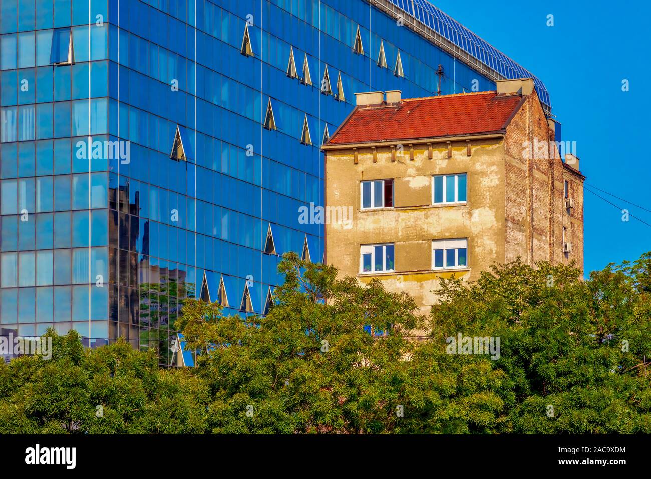 Ansicht einer alten Gebäude neben einem neuen modernen mit einer Glasfassade. Bild Stockfoto