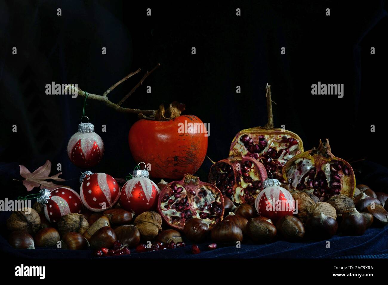 Herbst Früchte mit Weihnachten Kugeln auf schwarzem Hintergrund Stockfoto