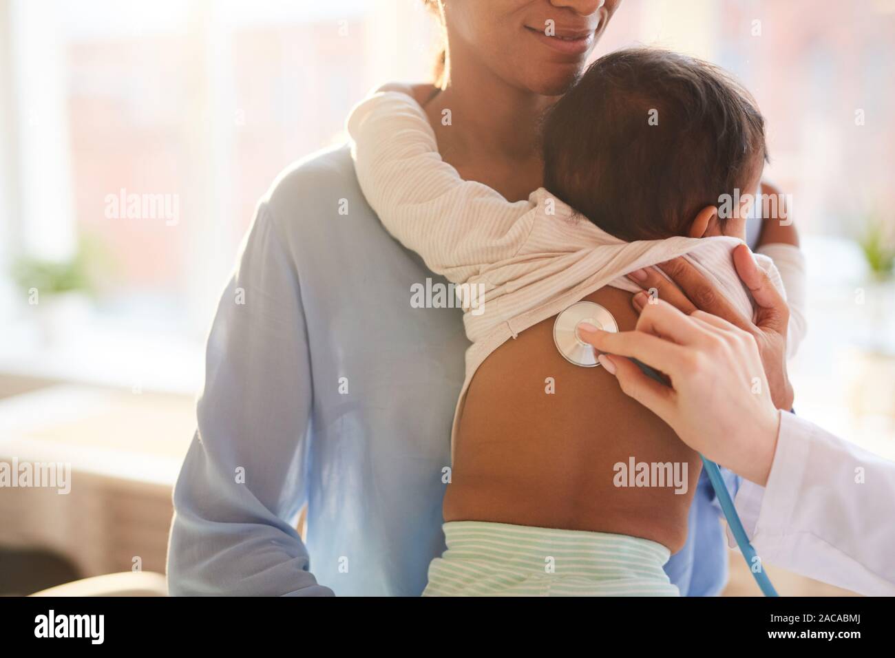 Nahaufnahme der Mutter, die ihr Baby beim Arzt Hören auf sein Herzschlag mit Stethoskop im Krankenhaus Stockfoto