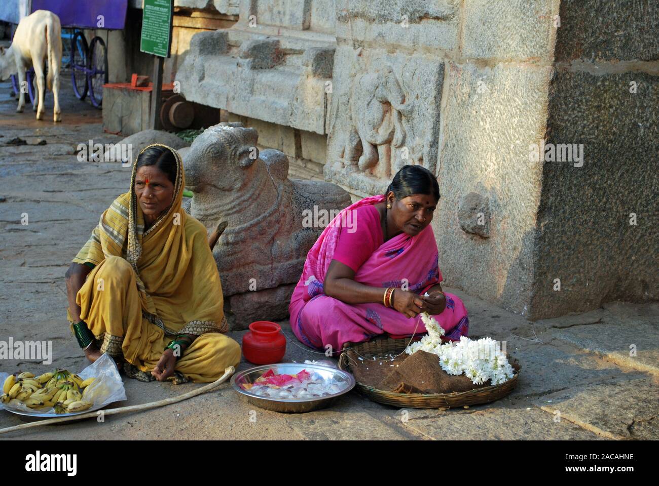 Indische Frauen bieten Blumen und Bananen für Verkauf, Hampi, Karnataka, Südindien, Asien Stockfoto