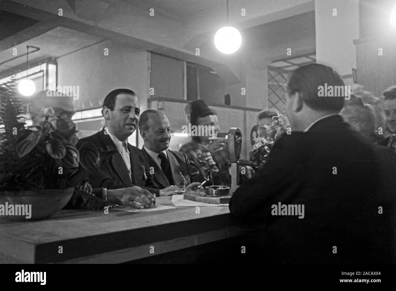 Messegänger begutachten einen Internet-adr., Leipzig, Sachsen, Deutschland, 1948. Die Messe Besucher untersuchen, einen Messestand, Leipzig, Sachsen, Deutschland, 1948. Stockfoto