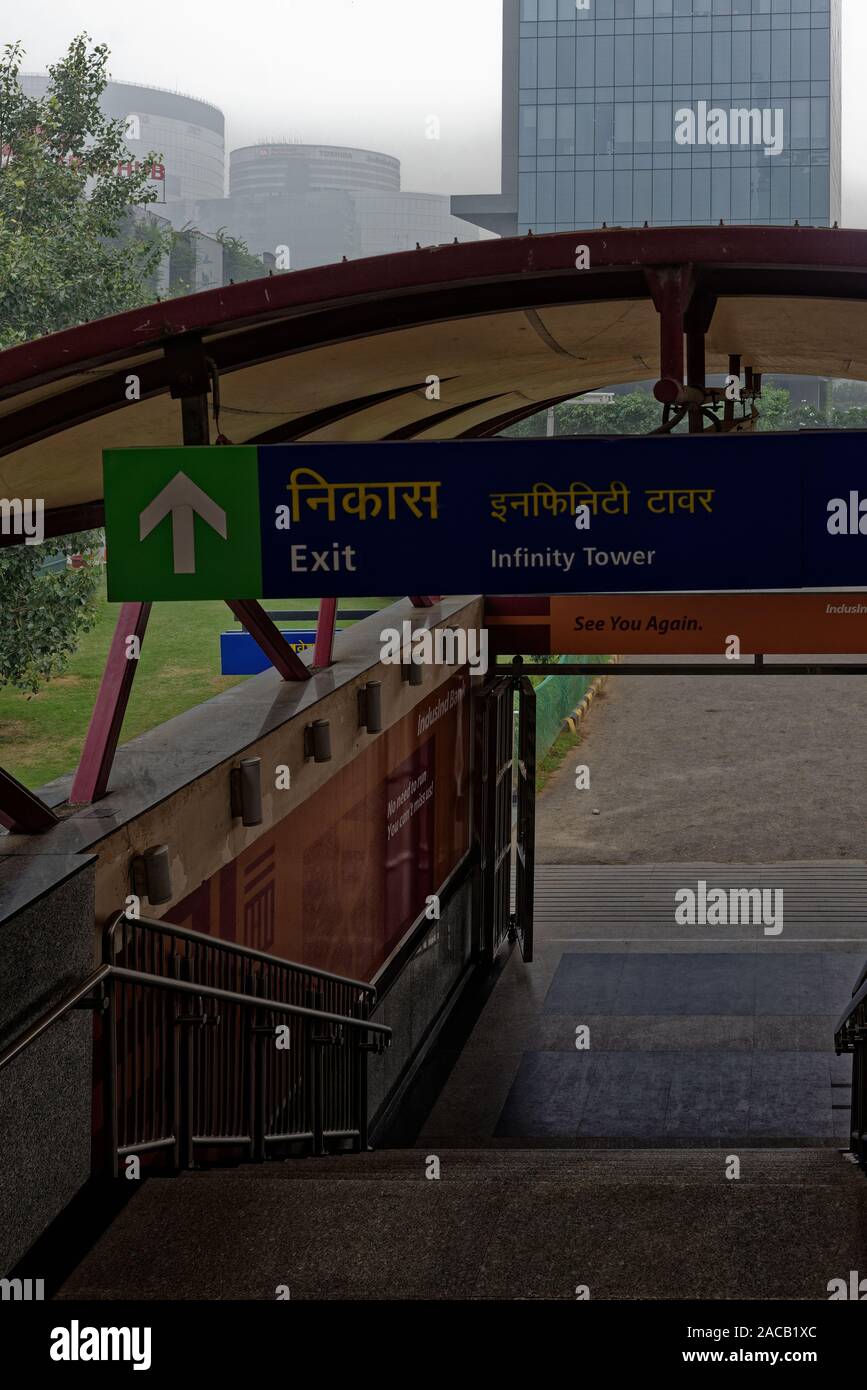 Die Ausfahrt der U-Bahn-Station Indusind, Gurgaon, Indien, ist ein Schild, das auf den Infinity Tower zeigt Stockfoto