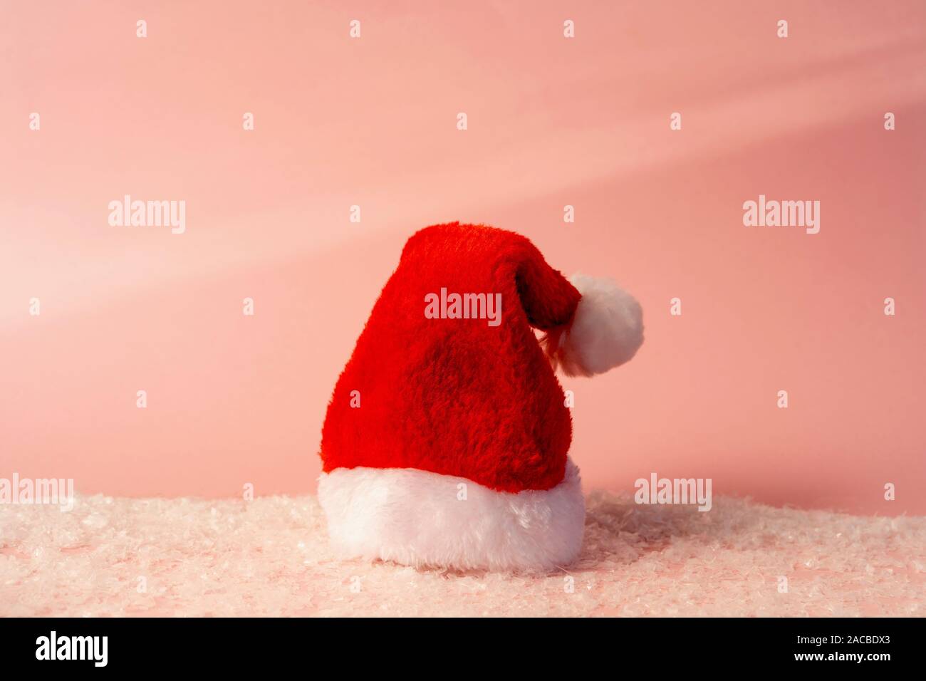 Santa claus red hat mit weißem Pelz auf Pastell rosa Hintergrund Stockfoto