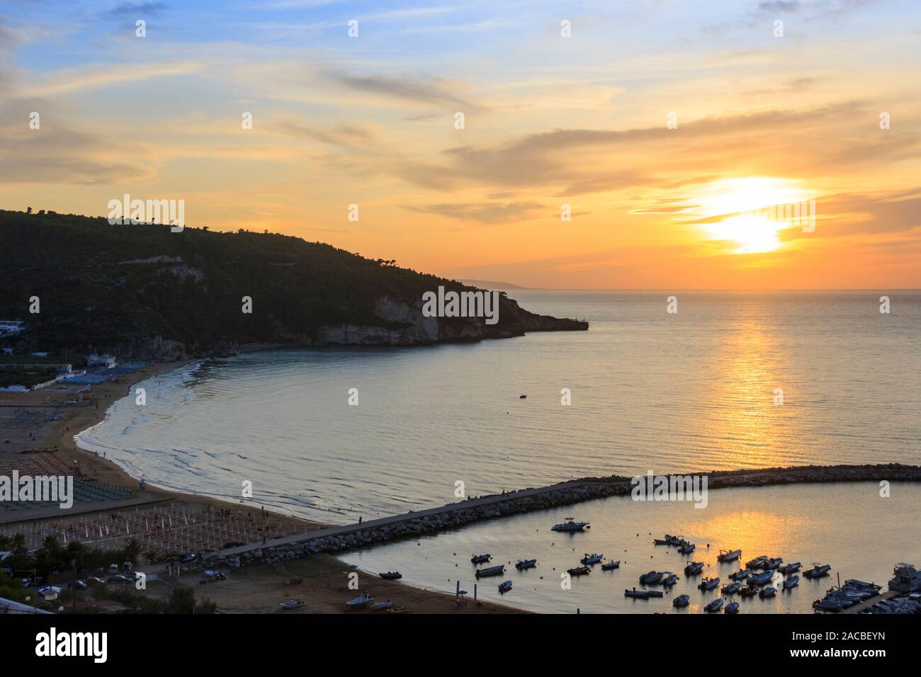 Panoramablick auf die Bucht von Peschici bei Sonnenuntergang: die Marina und den Sandstrand, Italien (Apulien). Peschici ist berühmt für seine Badeorte. Stockfoto