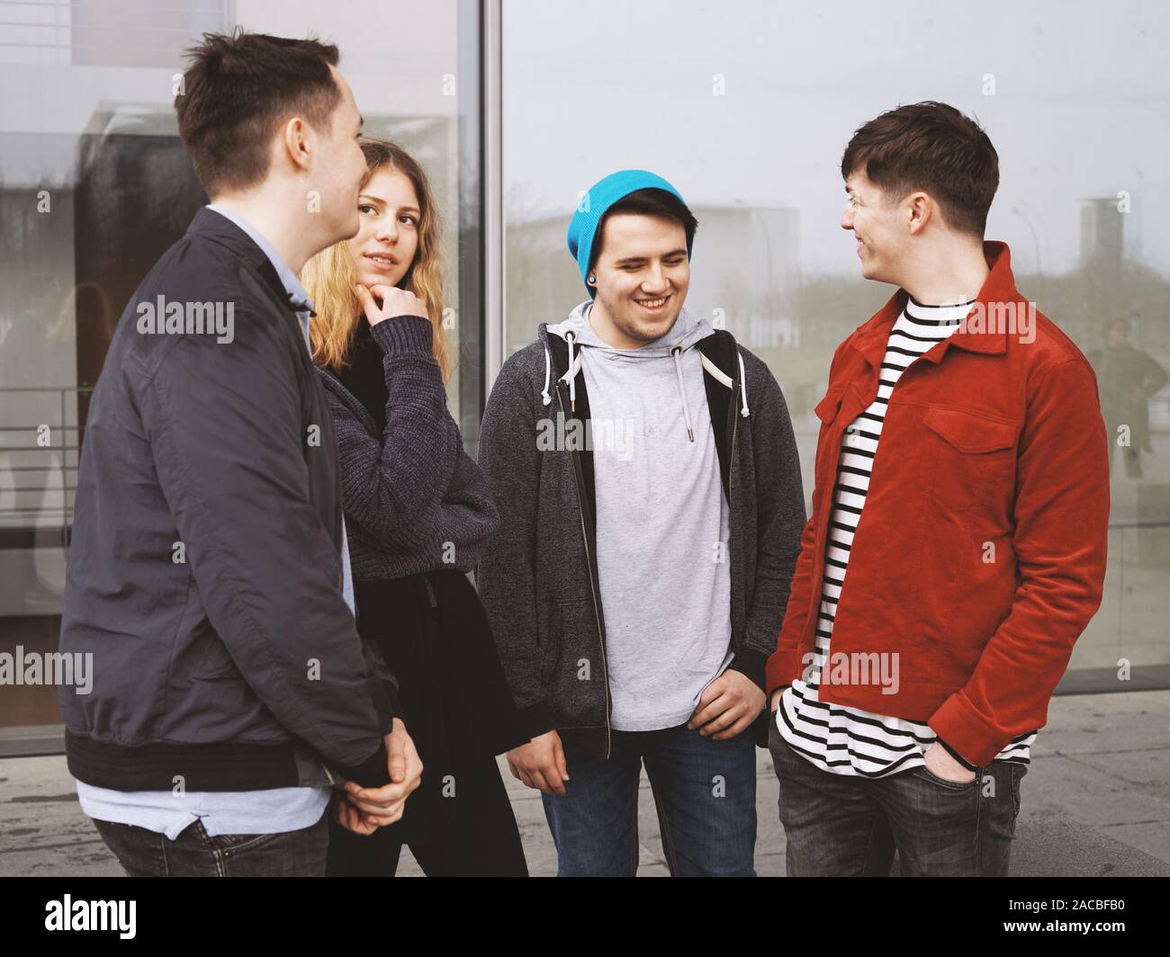 Gruppe von vier jungen städtischen Teenager Kumpels reden lachen und Spaß zusammen - ehrliche reale Personen Stockfoto