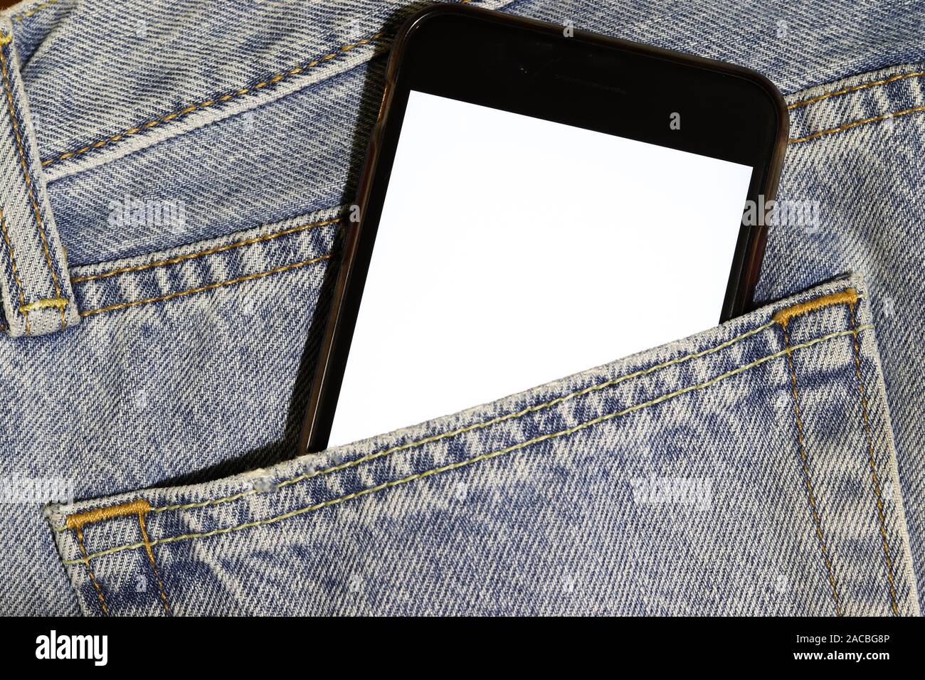 Verspotten Sie das Telefon mit weißem Bildschirm, das aus der Tasche der hellblauen Jeans pirschen kann. Vorlage verspott. Denim-Struktur. Gelegentliche Nutzung mobiler Inhalte. Kopierbereich Stockfoto