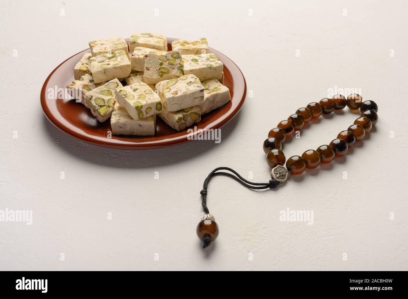 Osten Arabisch nougat Süße mit Pistazien auf einer Keramikplatte auf einem hellen Hintergrund. Nahaufnahme Stockfoto
