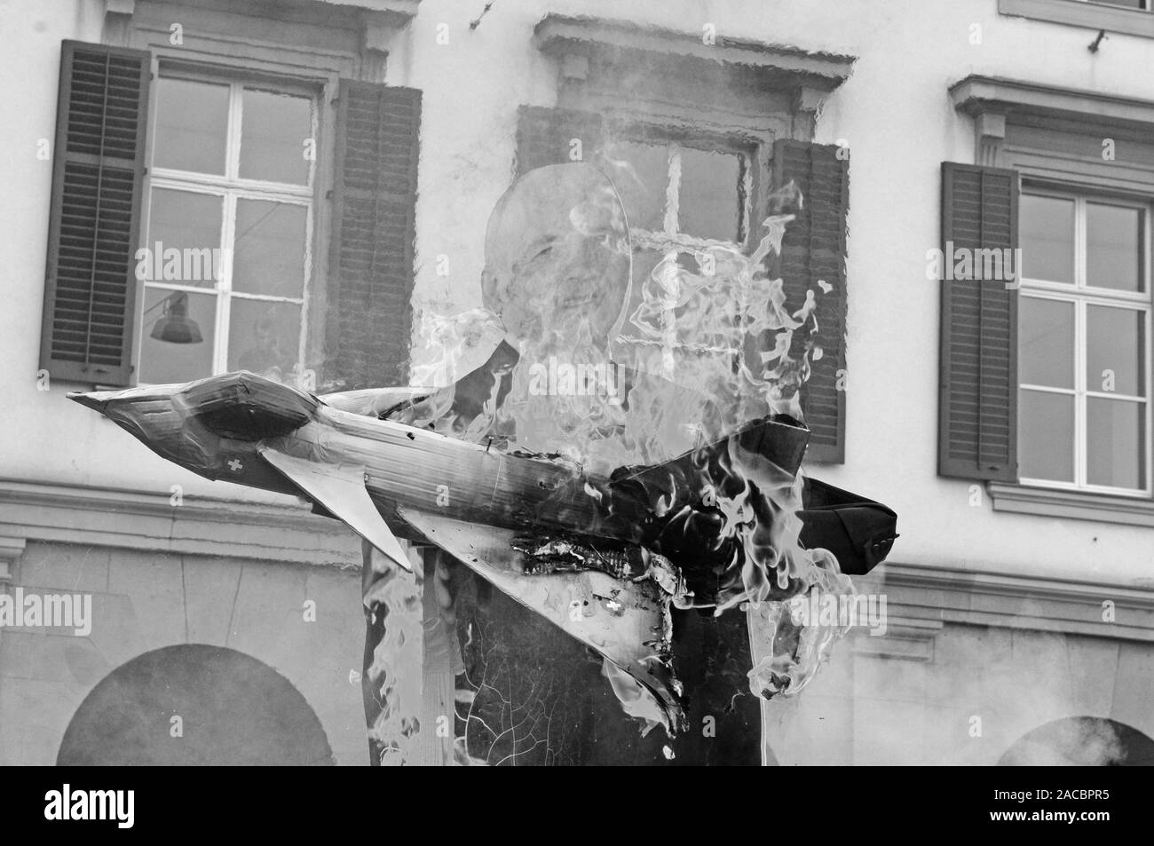 Schweiz: ein Dummy der Schweizer Bundesrat Ueli Maurer mit einem brennenden militärischen Jet fighter als Protest für das Schweizer Militär Luftfahrt Arma Stockfoto