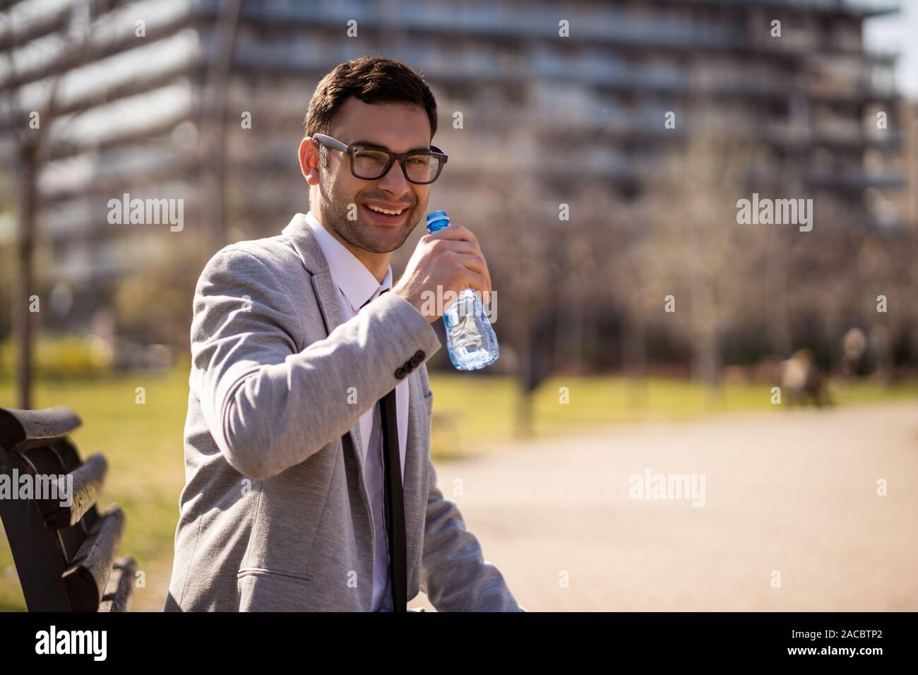 Junge Unternehmer ruht und Trinkwasser in den Park nach der Arbeit. Stockfoto