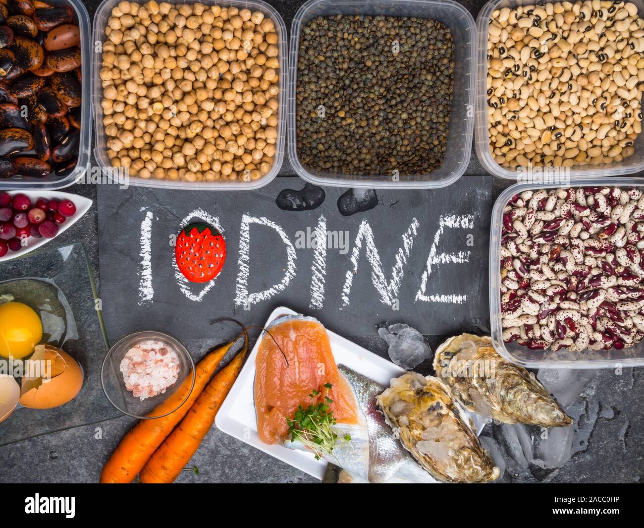 Produkte mit Jod Auster, Salz, Ei, Preiselbeeren, Fisch, Bohnen, Linsen, Karotte auf grauem Marmor Hintergrund Stockfoto