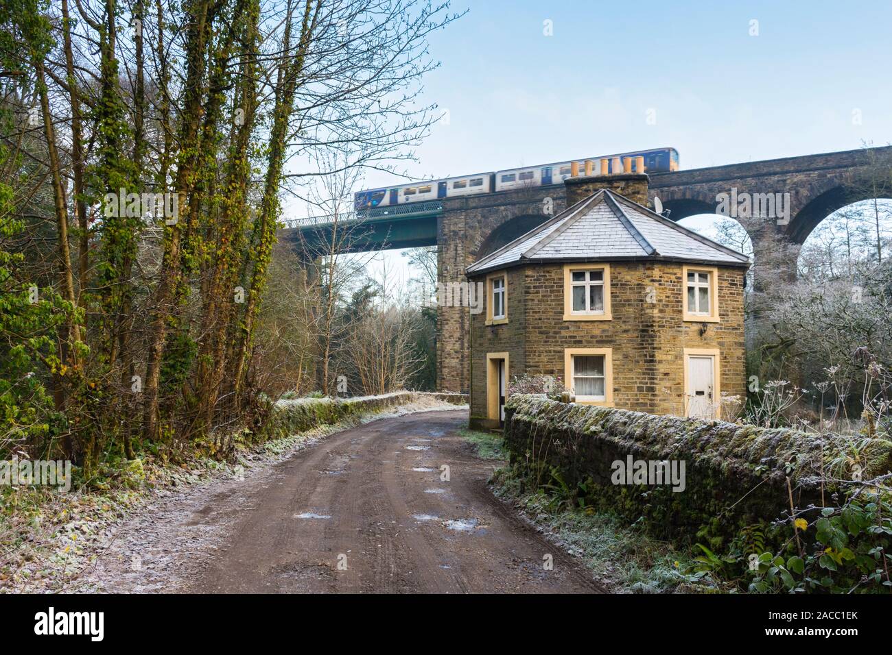 Schleuse Gate Cottage und ein Zug überquert die Bahn Viadukt (Hope Valley Line), Goyt Valley, in der Nähe von Marple, Greater Manchester, England, Großbritannien Stockfoto