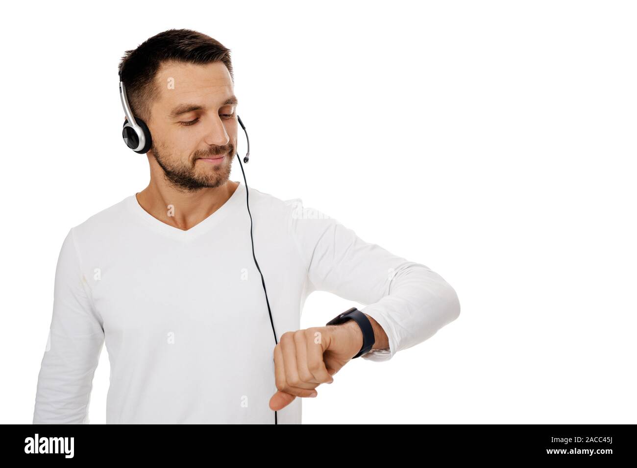 Call Center Mitarbeiter Mann mit Headset und schaut auf eine Wand auf weißem Hintergrund. Ihre Zeit sparen - Kundenservice anrufen Unterstützung Stockfoto
