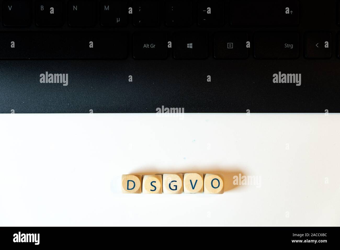Holzwürfel mit dem deutschen Wort "SGVO' für das Bipr zusammen mit einer Tastatur in Schwarz auf weißem Hintergrund - Ansicht von oben Stockfoto