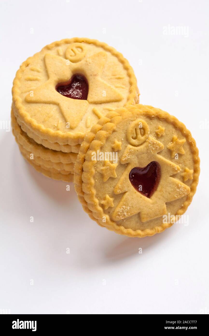 Stapel von Jammie Dodgers Himbeeraroma Kekse tis die Jahreszeit zu Jammie, Weihnachtsbaum und Star Designs auf weißem Hintergrund Stockfoto